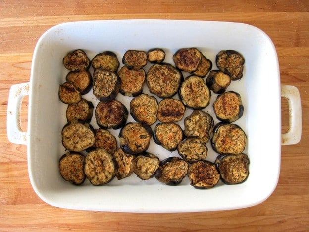 Roasted eggplant layered in a baking dish.