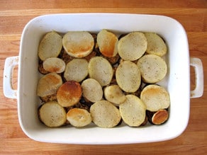 Roasted potatoes layered in a baking dish.