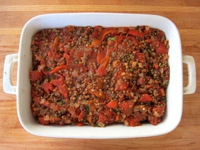 Lentil and vegetable mixture layered in a baking dish.