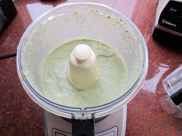 Basil and milk in a food processor.