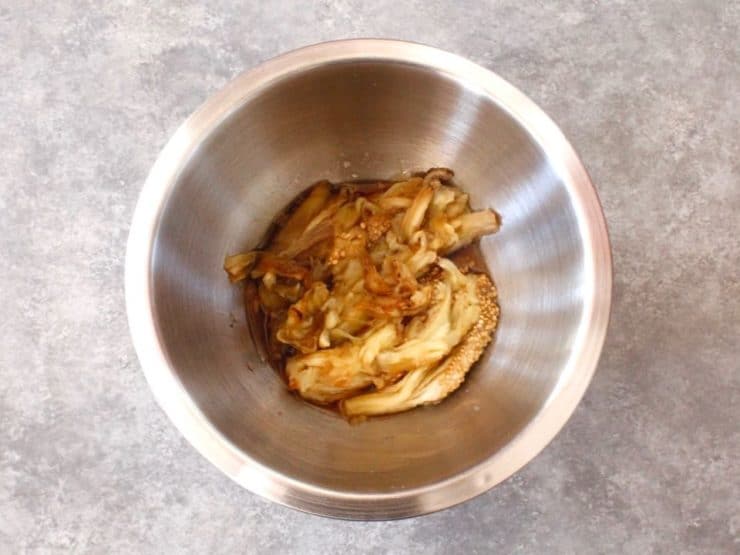 Roasted eggplant pulp in stainless steel bowl.
