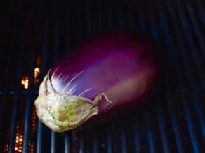 Whole fresh eggplant on grill.