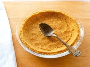 Spreading a graham cracker crust in a pie plate.