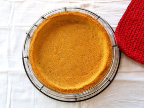 Baked graham cracker crust in a pie plate.