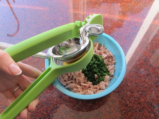 Juicing a lemon over tuna.