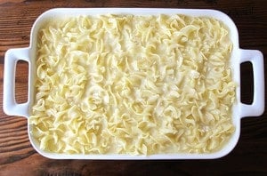 Coated noodles poured into a baking dish.