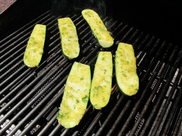 Zucchini halves on a grill, flesh side up.
