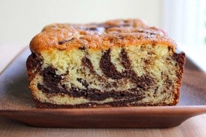 Baked marble cake sliced on wooden tray.