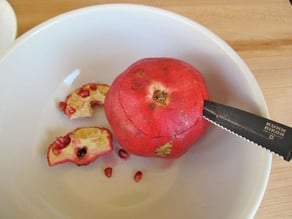 Slice the bottom off a pomegranate.