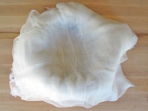 Cheesecloth-lined mesh colander.