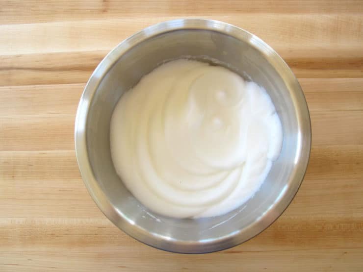 Egg whites beat to stiff peaks in a bowl.