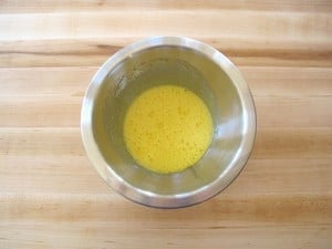 Egg yolks beaten in a small bowl.