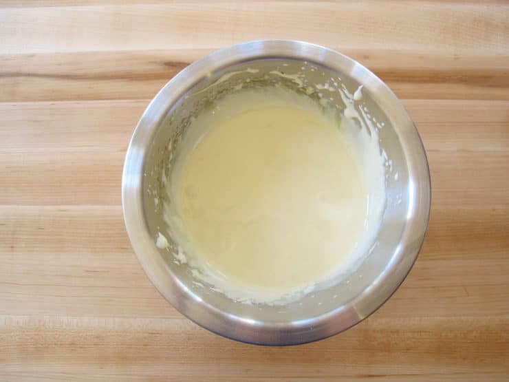 Sugar beaten into egg yolks in a mixing bowl.