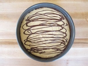 Melted chocolate drizzled on cheesecake filling.