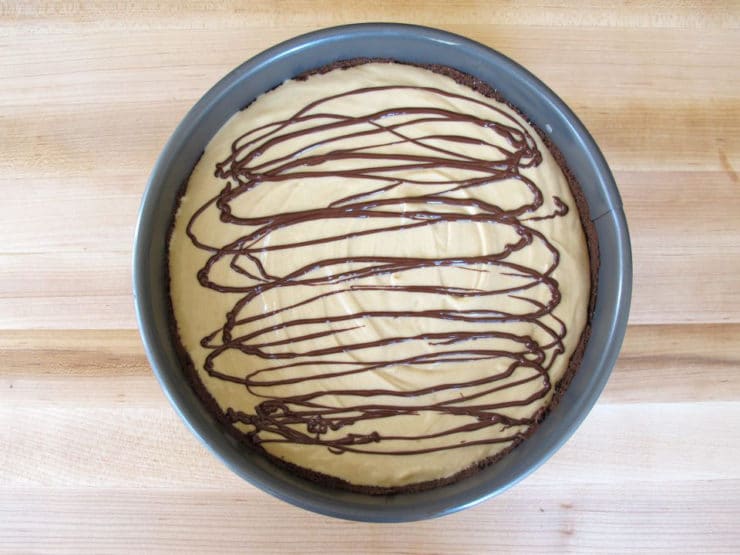Melted chocolate drizzled on cheesecake filling.