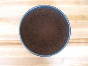 Chocolate cookie crumbs pressed into a springform pan.