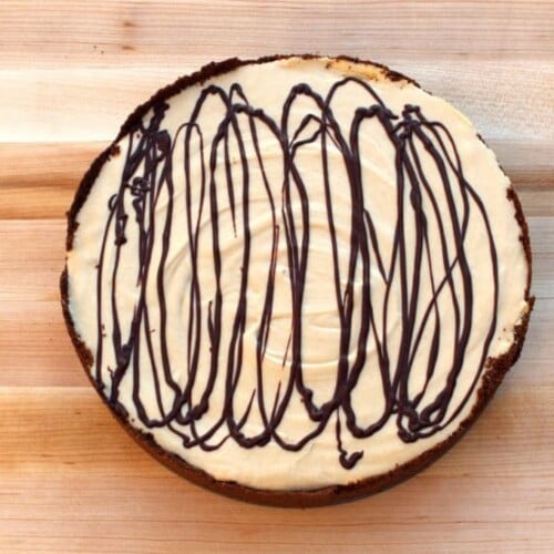 Top view of a peanut butter pie drizzled with chocolate syrup on top