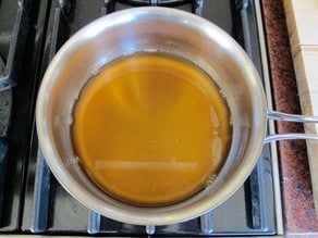 Gently warming honey in a saucepan.