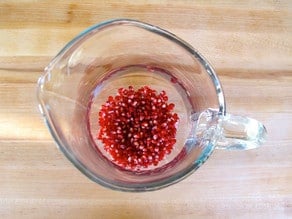 Pomegranate seeds in the bottom of a sangria pitcher.