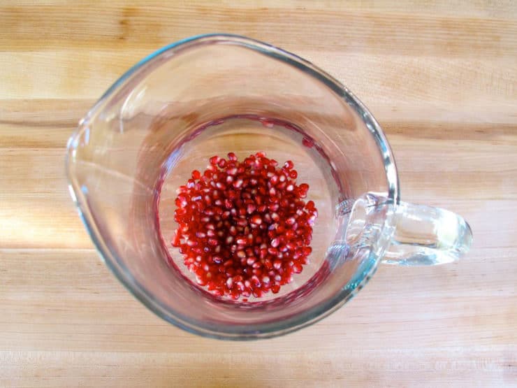 Pomegranate seeds in the bottom of a sangria pitcher.