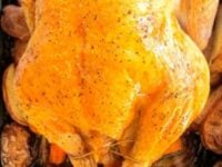 How to Truss a Chicken Pinterest Pin - roast chicken trussed in a roasting pan over root vegetables