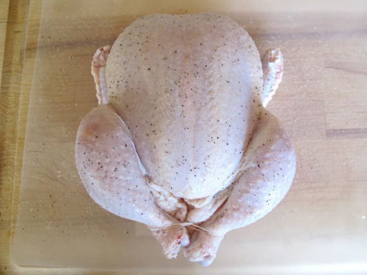 Trussed chicken on a cutting board.