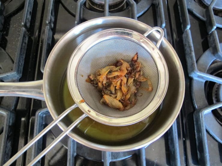 Straining pan drippings over a saucepan.