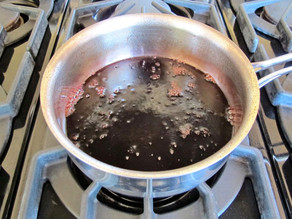 Pomegranate juice simmering in a saucepan.