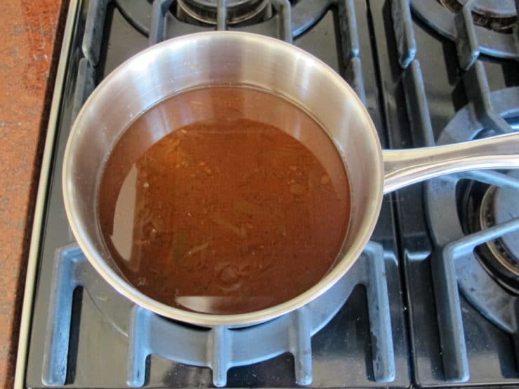 Beef brisket pan drippings in a saucepan.