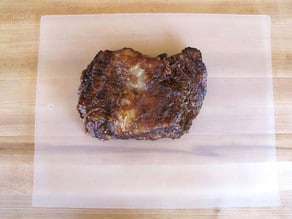 Beef brisket resting on a cutting board.