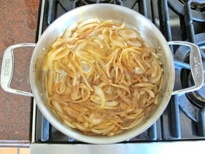 Sliced onions browning in a stockpot.