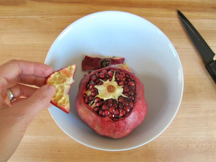 Pulling the crown off a pomegranate.