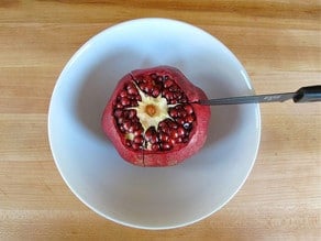 Make three shallow cuts in the sides of the pomegranate.