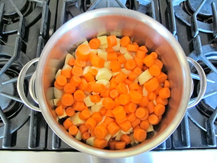Diced yams and carrots in a stockpot.