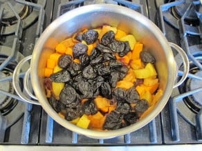 Pitted prunes added to stockpot of vegetables.