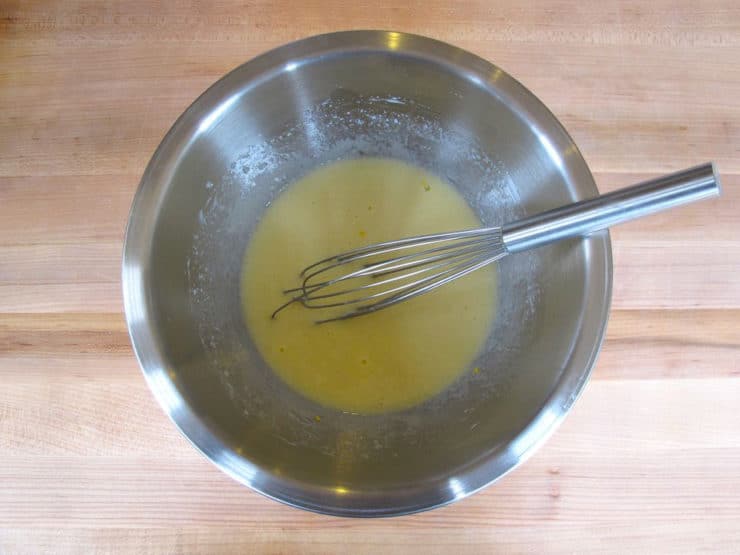 Eggs, buttermilk, and oil whisked together in a bowl.
