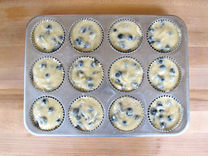 Blueberry muffin batter in a lined muffin tin.