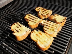 Toasting challah slices on a grill.