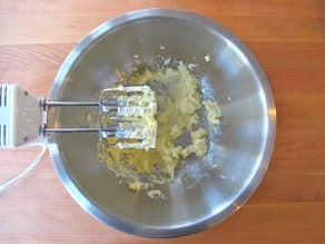 Creaming butter into sugar with a hand mixer.