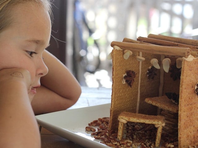 Little girl gazing at her assembled and decorated mini sukkah.