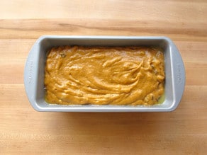 Pumpkin cake batter in a greased loaf pan.