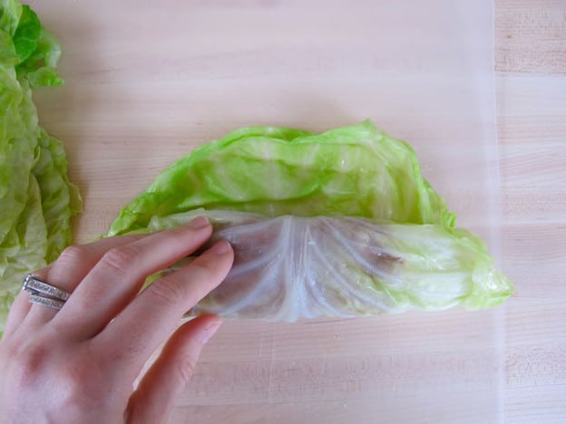 Rolling cabbage leaves around filling.