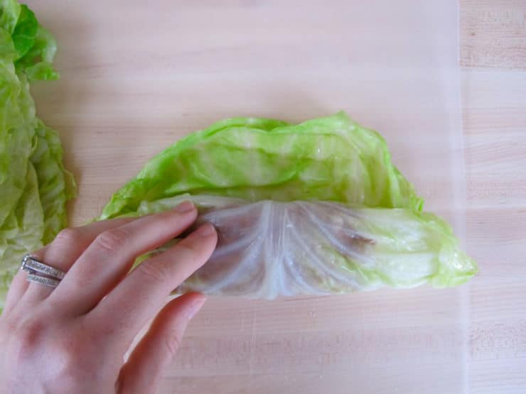 Rolling cabbage leaves around filling.
