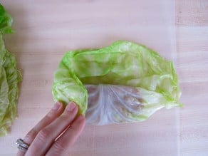 Rolling cabbage leaves around filling.