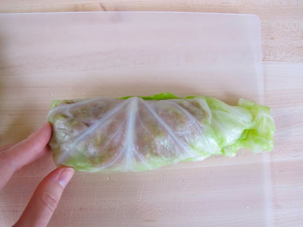 Rolling cabbage leaves around filling.