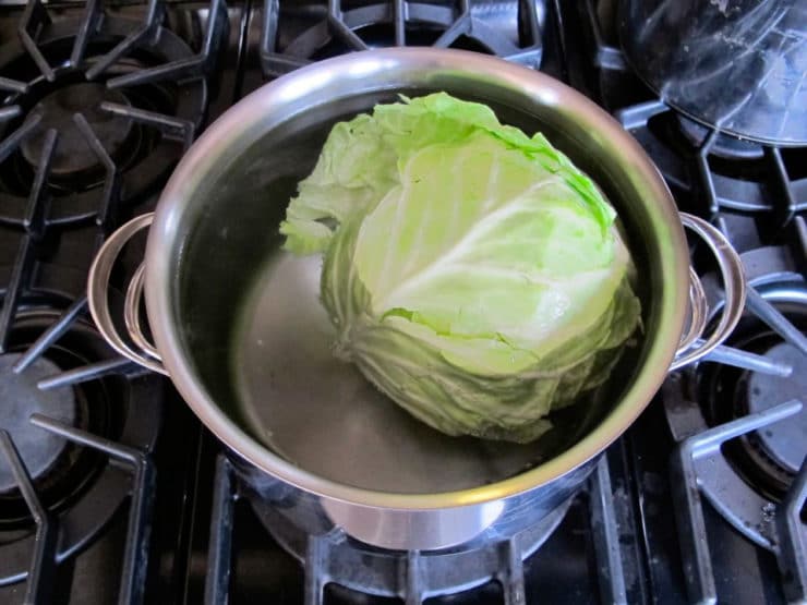 Parboiling a head of cabbage.