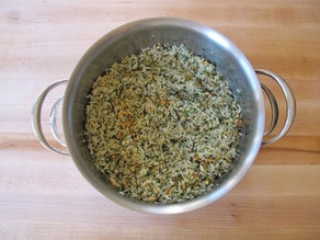 Seasoning and pine nuts stirred into rice.