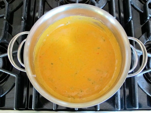 Whisking paprika into cheese sauce.