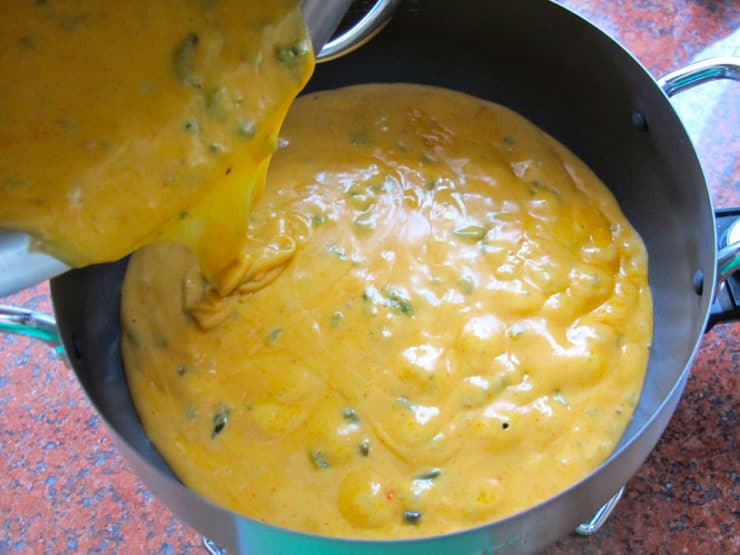 Pouring melted cheese into fondue pot.