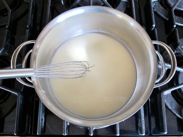 Dissolving cornstarch into liquid in a saucepan.